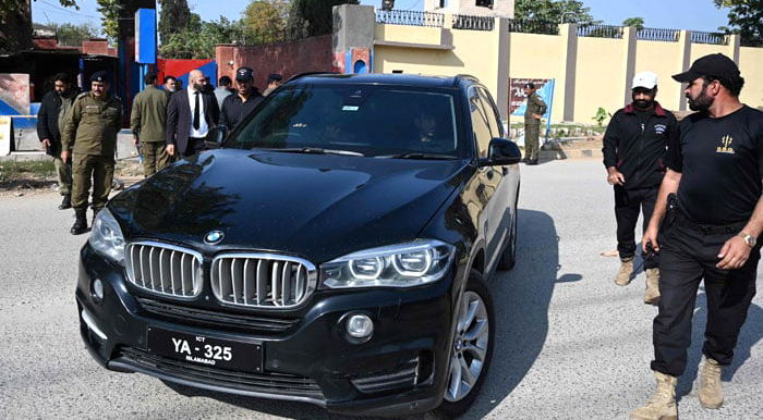 Bushra Bibi being taken into a car to Adiala jail